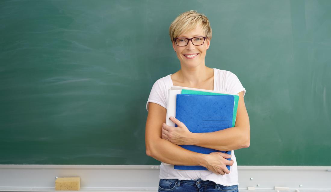 Lehrerin steht vor Tafel