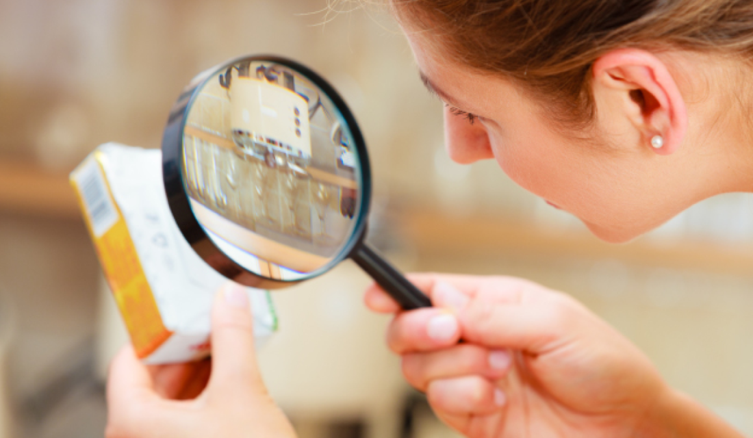 Verpackung wird mit Lupe betrachtet