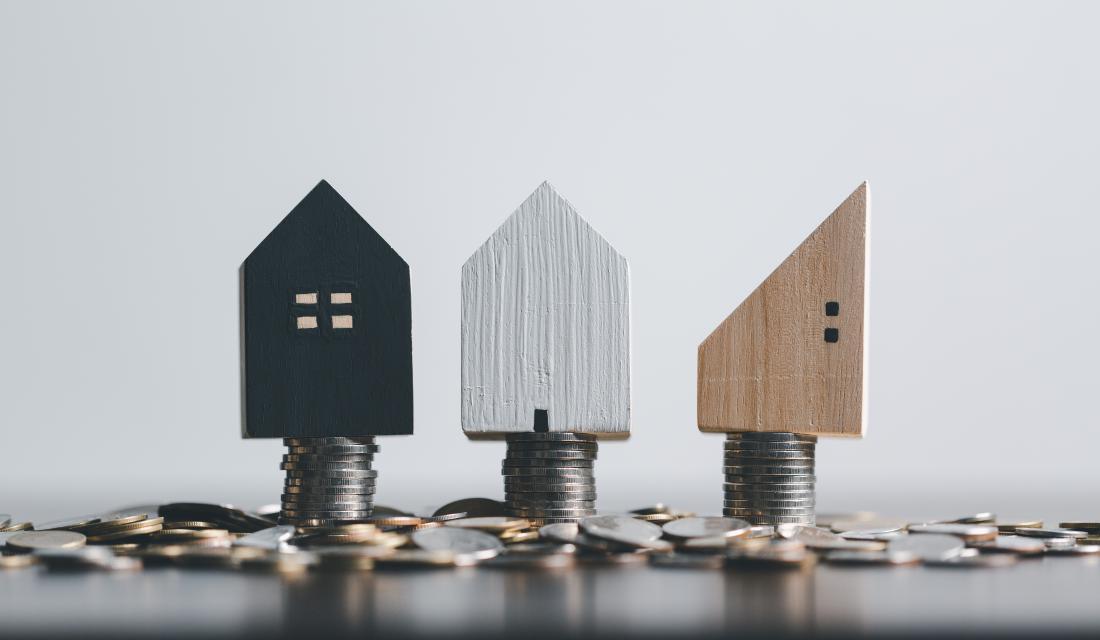 Bild mit Häusern, die auf Euro-Münzen stehen.