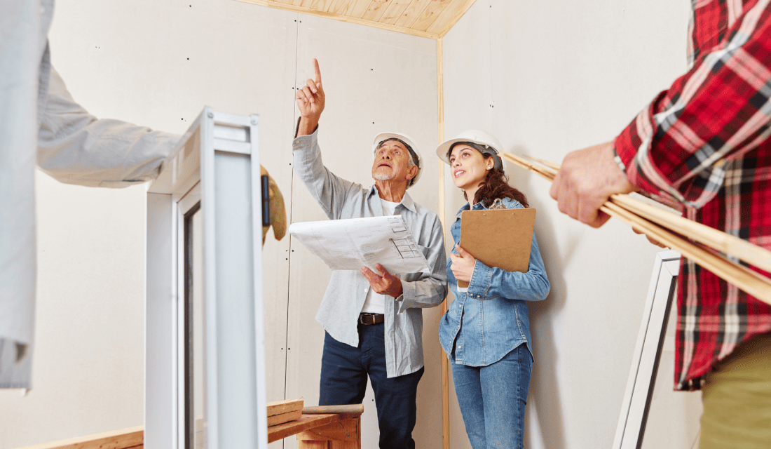 Menschen mit Helm schauen an die Decke in einem Haus