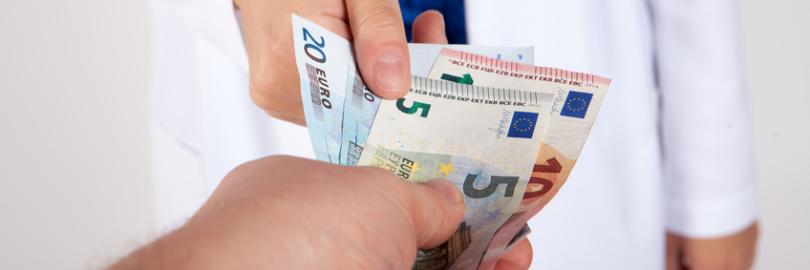Arzt nimmt Geldscheine entgegen