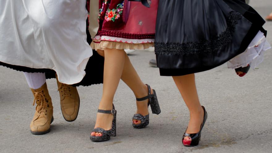 Hüpfende Füße und Beine von drei jungen Frauen im Dirndl