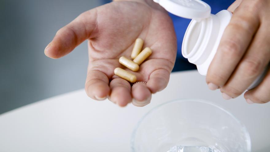 Tabletten für Nahrungsergänzungsmittel auf Handfläche geschüttet