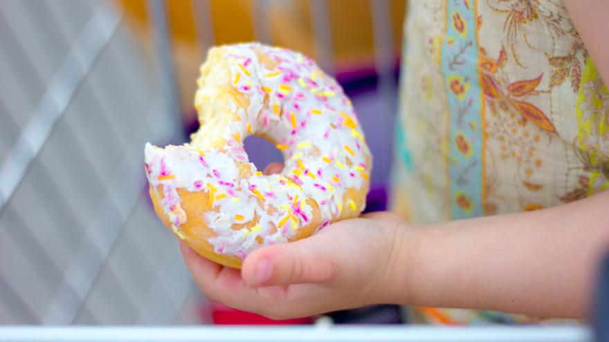 Angebissener Donut in Kinderhand