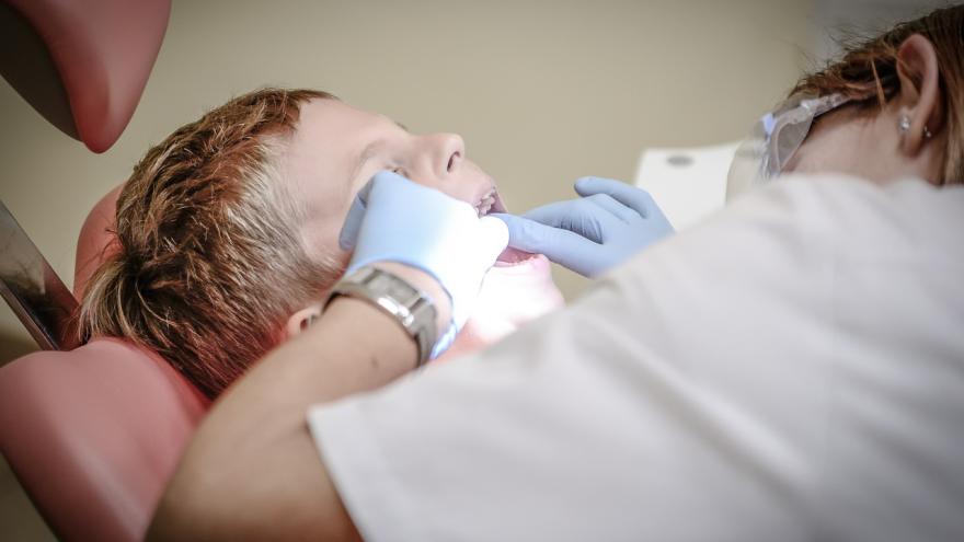 Kind in einem Zahnarztstuhl bei der Untersuchung