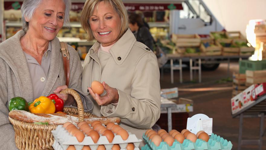 Zwei Damen kaufen Eier auf dem Markt