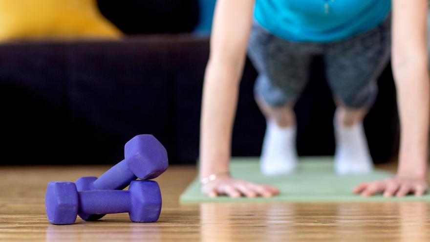 Junge Frau macht Sport im Vordergrund liegen Hanteln