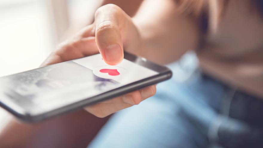 Frau drückt auf Herzchen auf Dating App