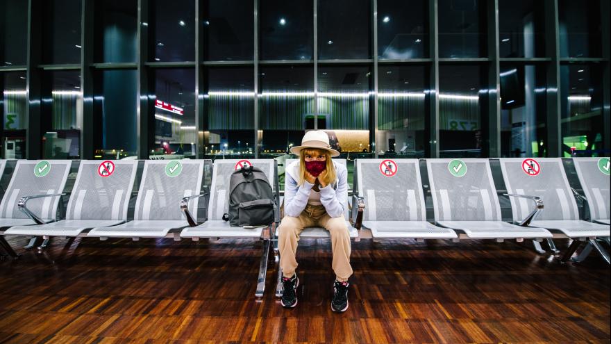 Frau sitzt alleine im Flughafen