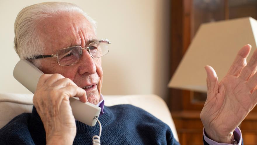 Senior telefoniert mit Festnetztelefon