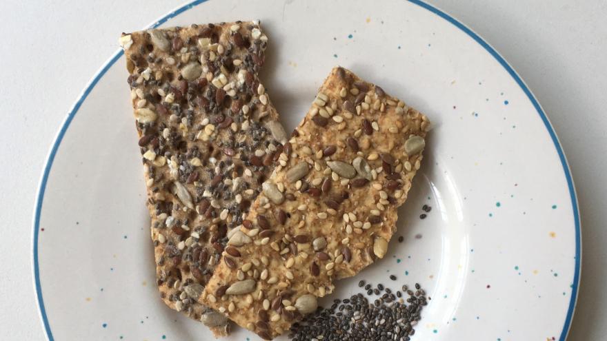 Zwei Scheiben Knäckebrot auf einem Teller, daneben liegen Chiasamen