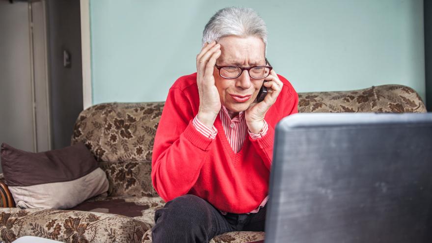 Seniorin ärgert sich am Telefon und Laptop