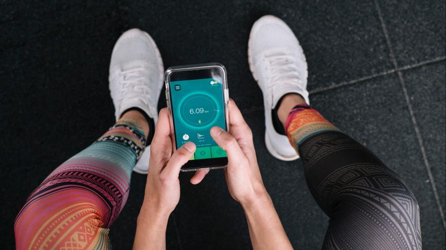 Sportmensch hält Fitness-App in der Hand