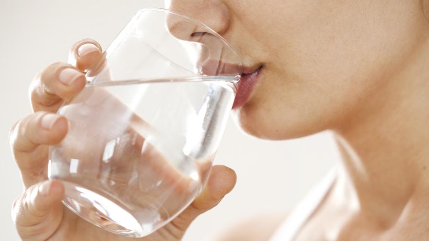 Frau trinkt Wasser aus einem Glas 