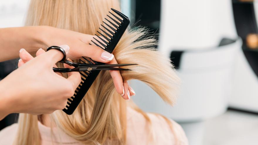 Person bekommt Haare beim Friseur geschnitten