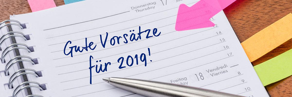 Auf einem Kalenderblatt steht die Überschrift "Gute Vorsätze für 2019!"