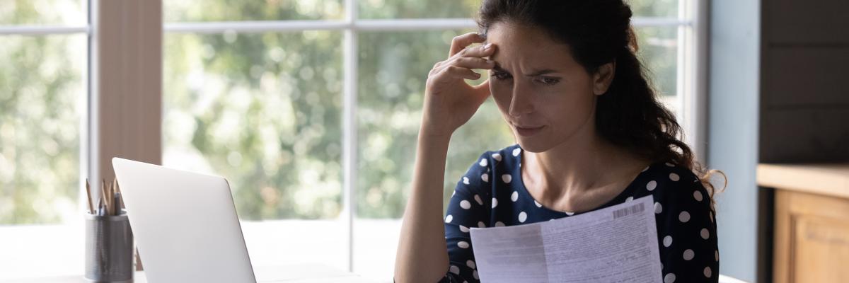 Frau schaut auf Schreiben von der Bank