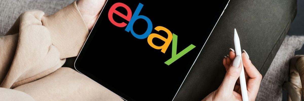 Tablet auf dem Schoß einer Person mit dem Logo "ebay" auf dem Display