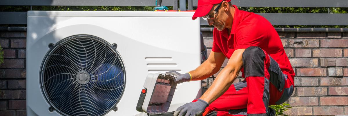 Ein Techniker bei der Aufstellung einer Wärmepumpe in einem Garten
