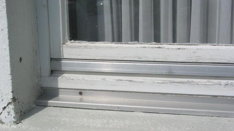 alte, weiße Fensterrahmen in schlechtem Zustand