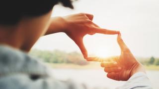 Mann fängt Bildausschnitt mit Fingern ein