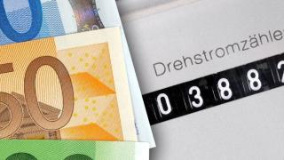 Geldscheine liegen auf einem Stromzähler