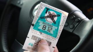 Mensch hält Vignette für Österreichische Autobahn in der Hand