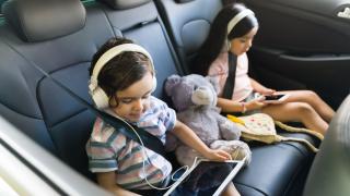 Kinder mit Tablet und Smartphone im Auto
