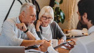 Ältere Menschen schauen auf ein iPad in einer Beratung
