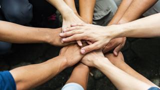 Hände übereinander im Team