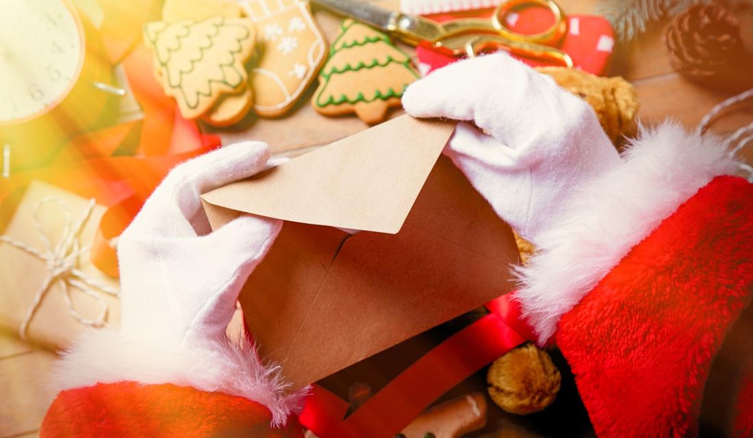 Hände des Weihnachtsmanns schließen einen Brief